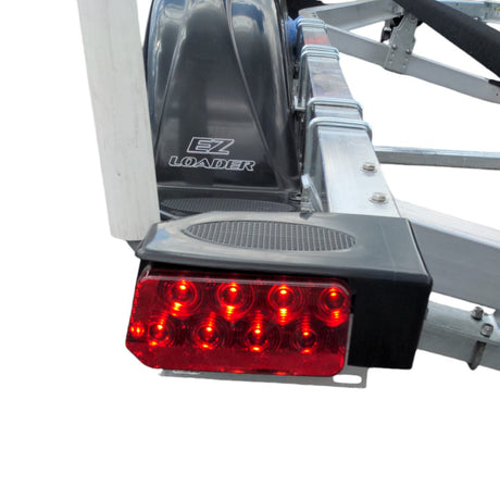 EZ Loader trailer LED tail light with protective housing mounted on frame showing wiring and marine lighting setup