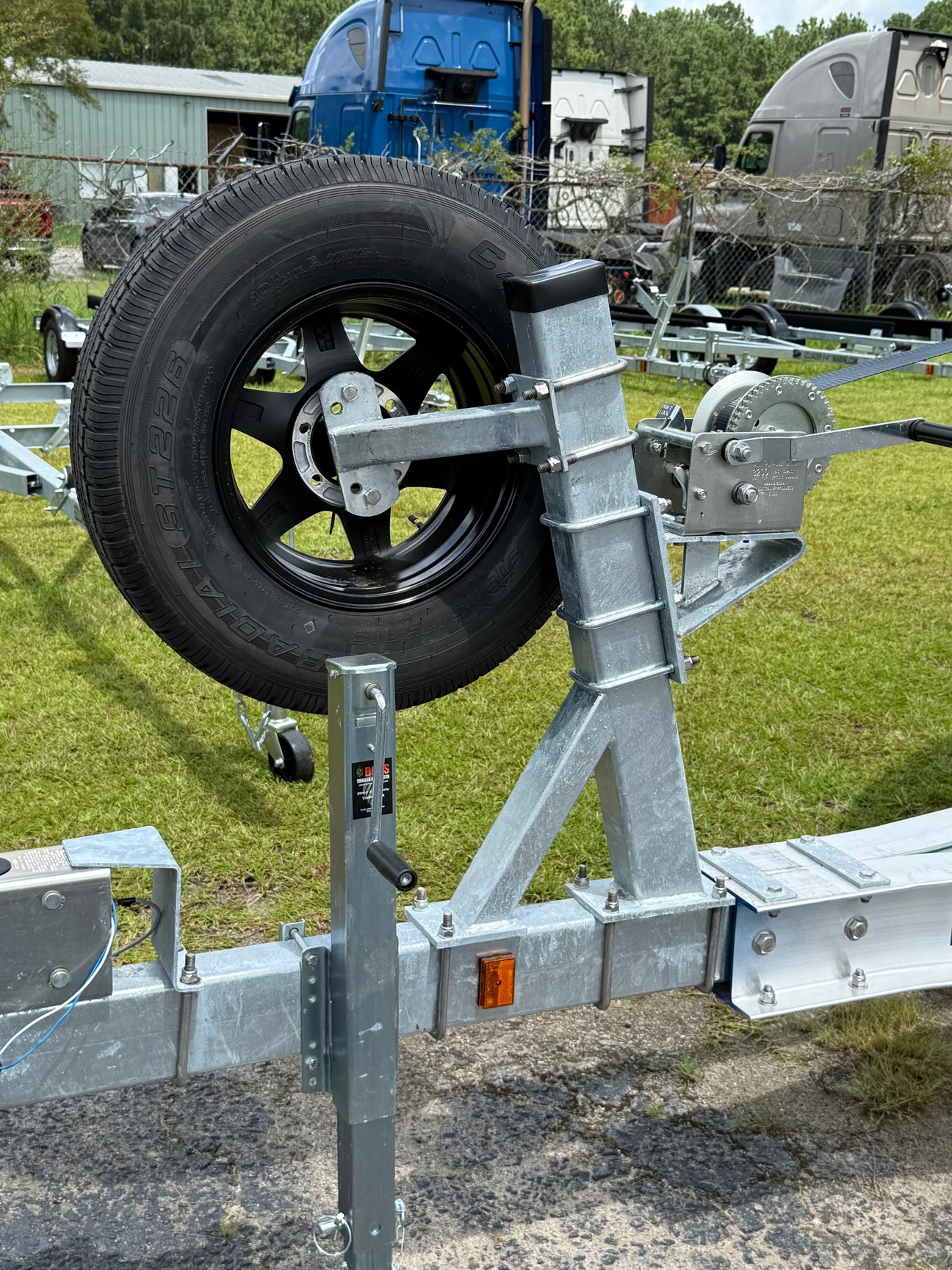 EZ Loader trailer spare tire carrier mounted on frame holding wheel above waterline for marine use