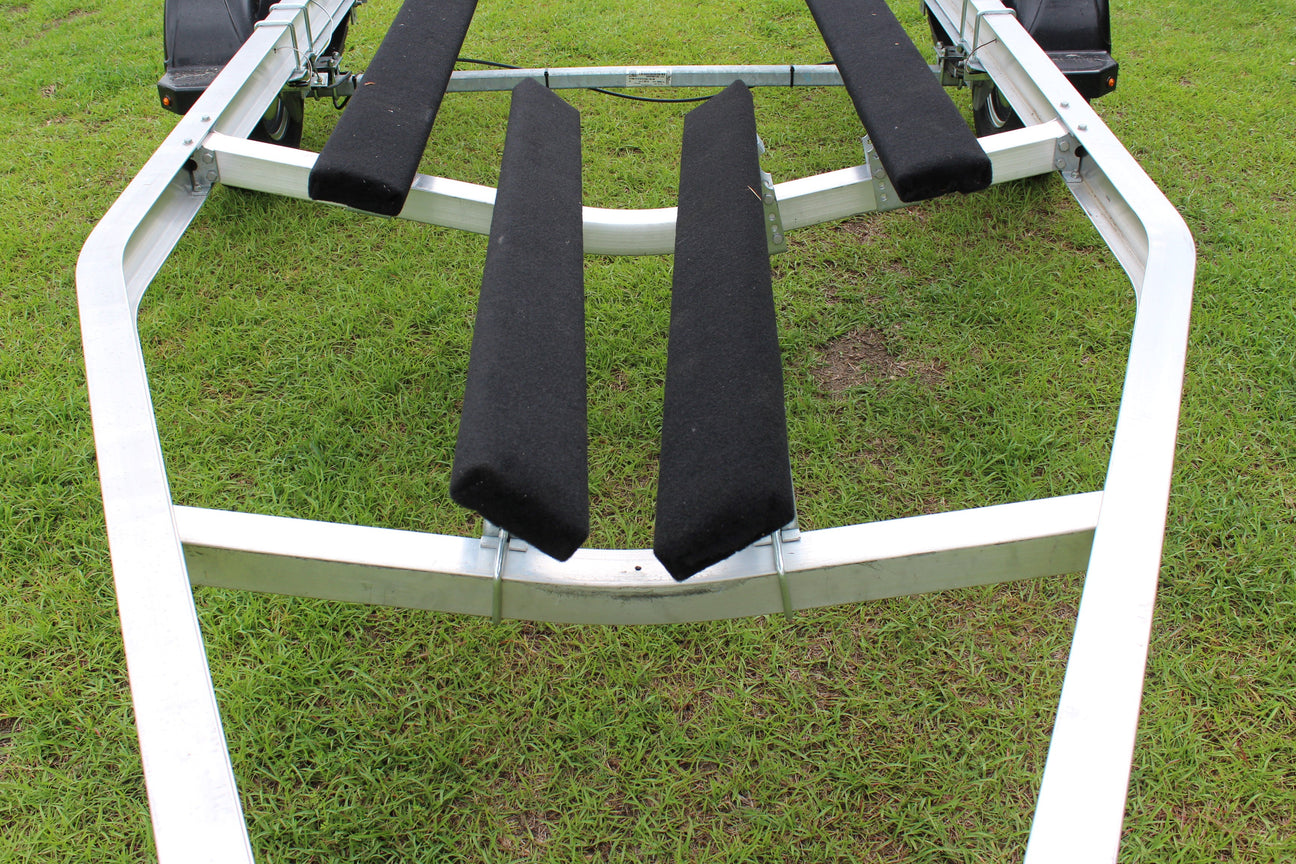 EZ Loader boat trailer crossmember supporting bunk brackets and carpeted bunks on aluminum trailer frame