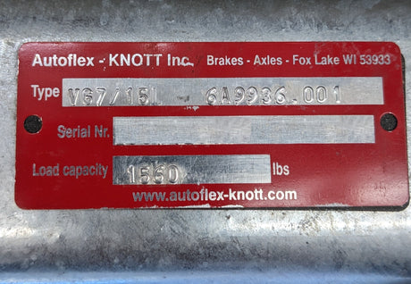 Red metal tag with text and serial number on a gray background