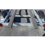 Metal boat trailer on a gravel surface showing knott axle 
